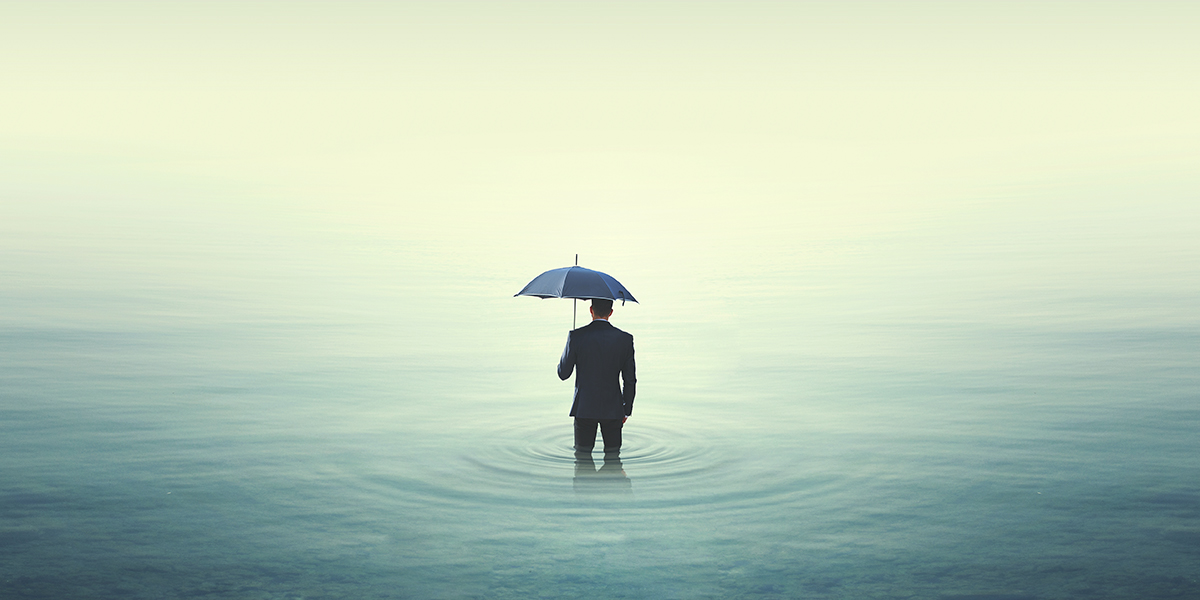 Person in water holding umbrella.